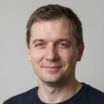 Улыбающийся клиент Zodk, изучивший волатильность слотов с греческой мифологией перед началом игры